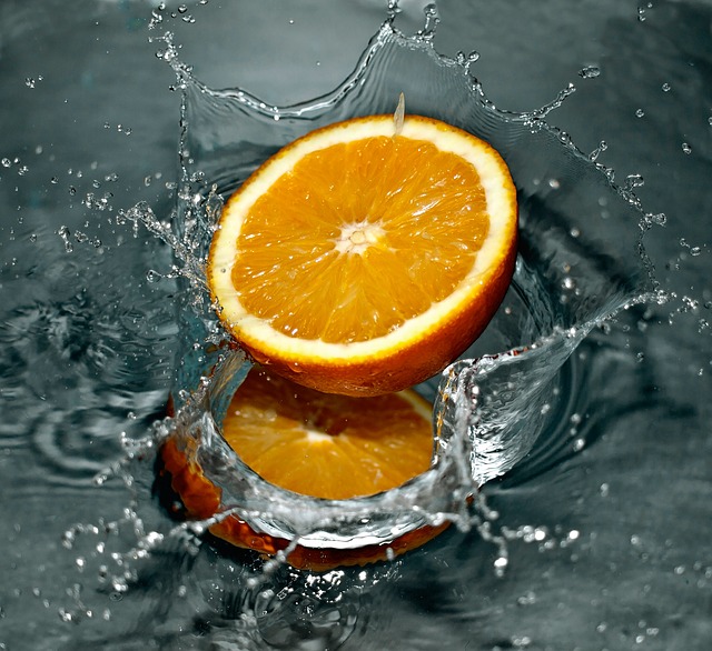 Half an orange splashing in water